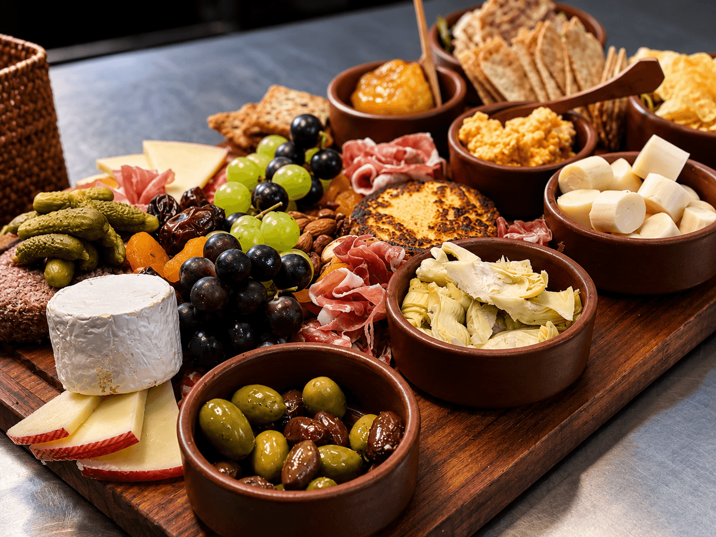 A beautifully arranged charcuterie board featuring various cheeses, meats, fruits, and crackers.