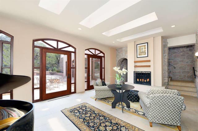 Bright and modern living room with large windows, comfortable seating, and a cozy fireplace.