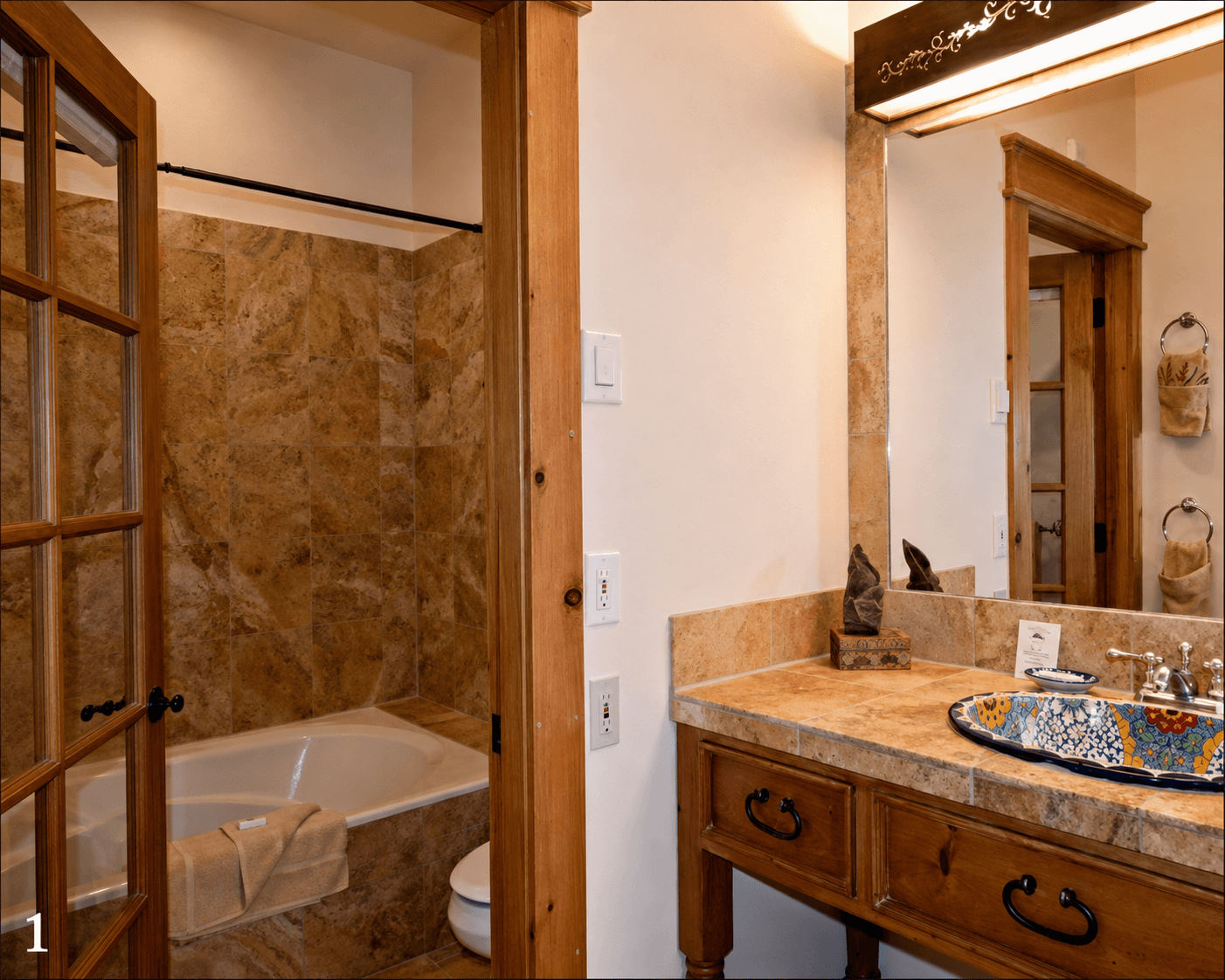 A cozy bathroom featuring a bathtub, wooden cabinetry, and a decorative sink.
