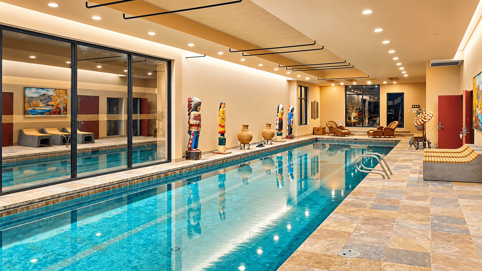 Indoor swimming pool with decorative sculptures and lounge seating.