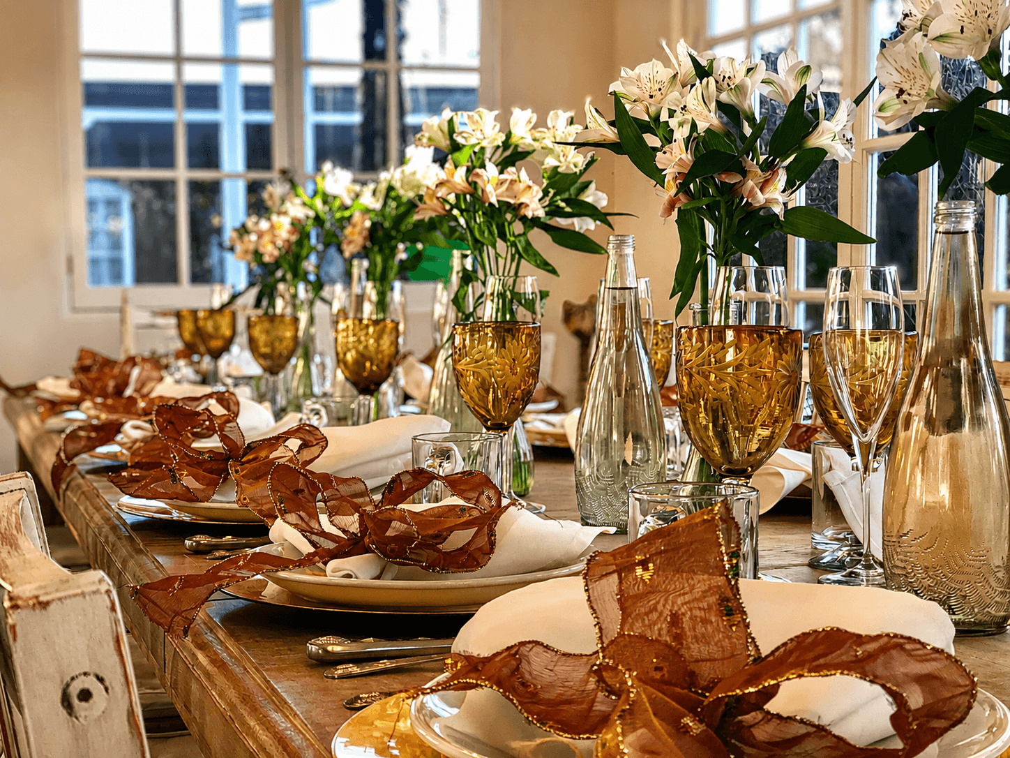A beautifully set dining table adorned with floral centerpieces and elegant glassware.