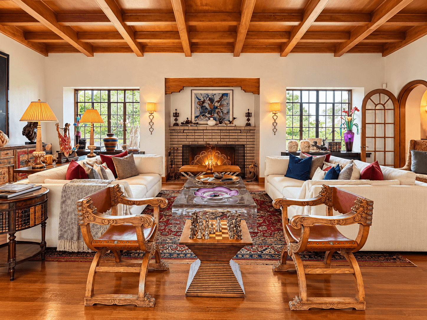 A cozy living room featuring two armchairs, a fireplace, and a mix of colorful cushions and decor.